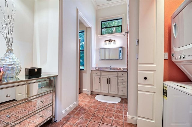 bathroom with tile patterned flooring, stacked washer / drying machine, vanity, and ornamental molding