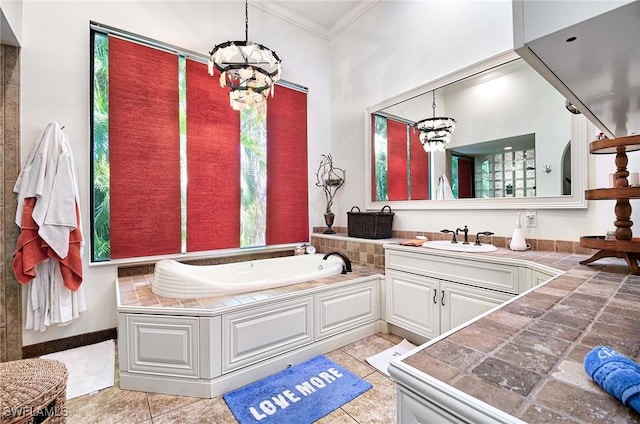 bathroom with tile patterned flooring, vanity, a bath, ornamental molding, and a chandelier