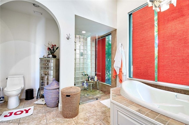 bathroom with tile patterned flooring, shower with separate bathtub, and toilet