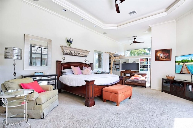 bedroom with multiple windows, a tray ceiling, and crown molding