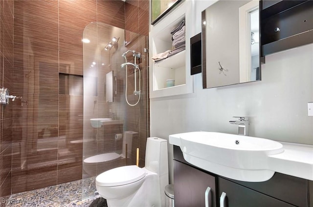 bathroom featuring vanity, toilet, and tiled shower