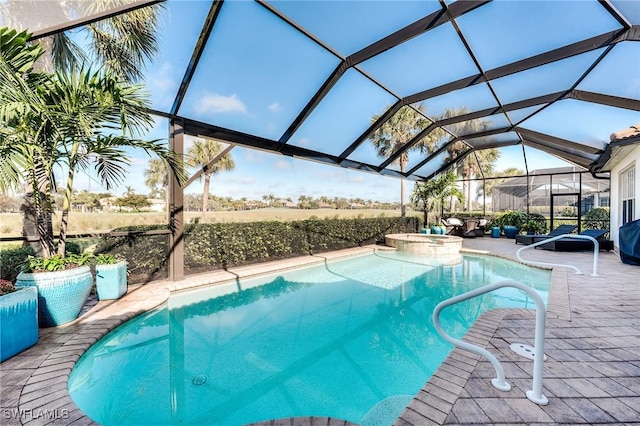 view of pool with a patio area, glass enclosure, and an in ground hot tub