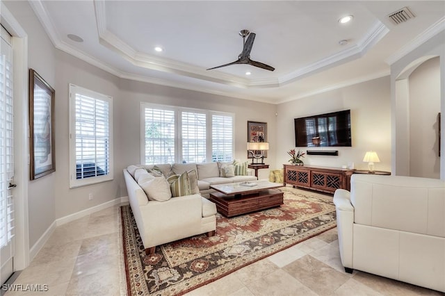 tiled living room with crown molding, ceiling fan, and a tray ceiling