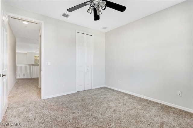 unfurnished bedroom with ceiling fan, a closet, and light carpet