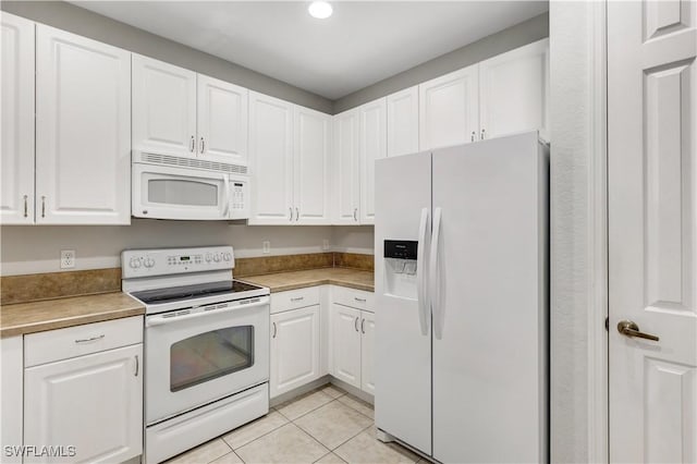 kitchen featuring white appliances, white cabinets, and light tile patterned flooring