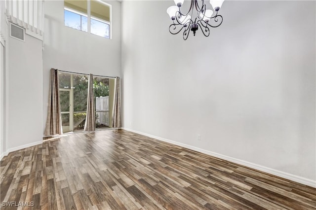 interior space with hardwood / wood-style flooring, a high ceiling, and an inviting chandelier