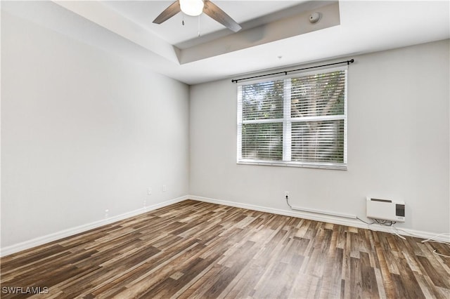 spare room with hardwood / wood-style flooring, ceiling fan, and a raised ceiling