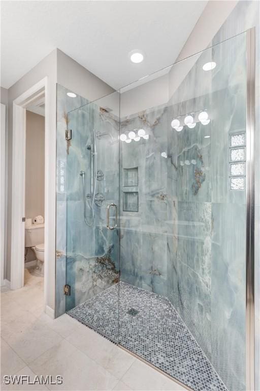 bathroom featuring an enclosed shower, tile patterned floors, and toilet