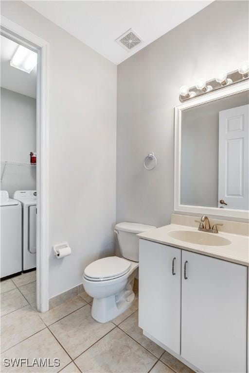 bathroom with tile patterned flooring, vanity, independent washer and dryer, and toilet