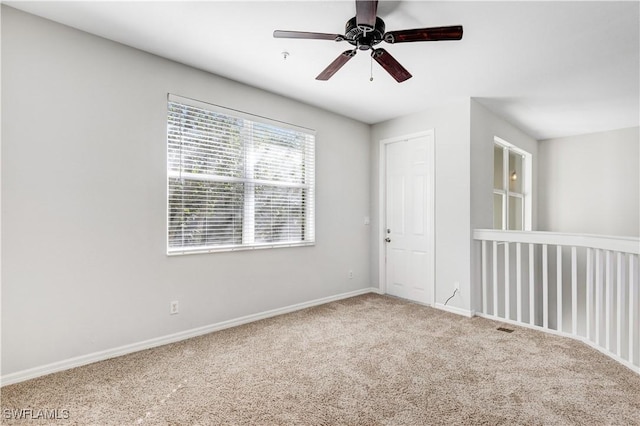 spare room featuring ceiling fan and carpet floors