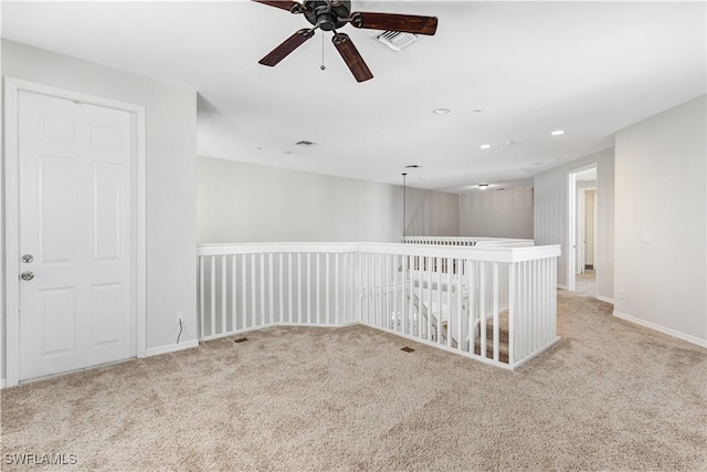 spare room with light colored carpet and ceiling fan