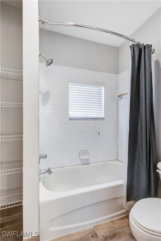 bathroom featuring shower / bathtub combination with curtain and toilet