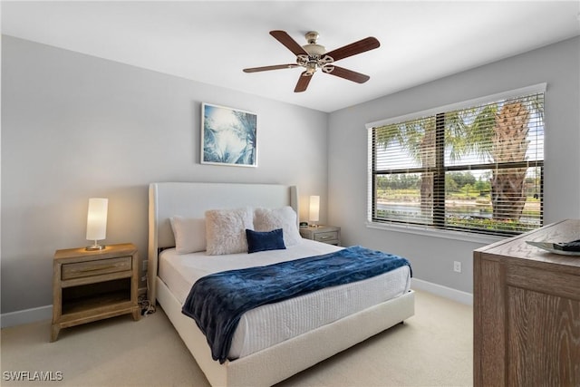 bedroom featuring light carpet, baseboards, and a ceiling fan
