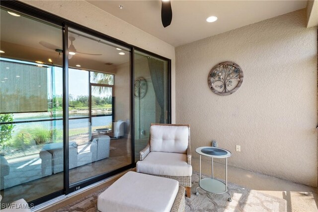 sitting room featuring a ceiling fan, a textured wall, and recessed lighting