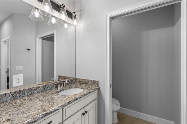 bathroom with tile patterned flooring, toilet, vanity, and baseboards