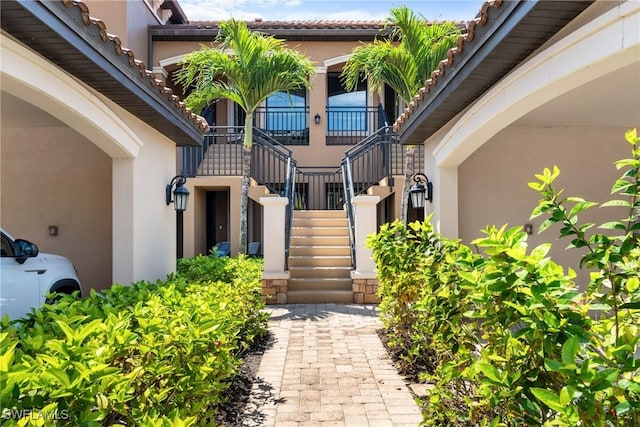 property entrance with stucco siding and a tile roof