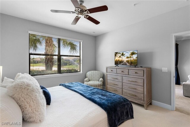 bedroom featuring light colored carpet, baseboards, and ceiling fan
