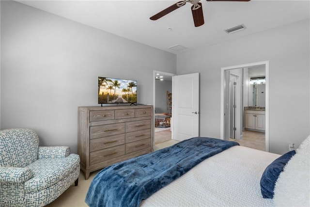 bedroom featuring light carpet, a ceiling fan, and ensuite bathroom