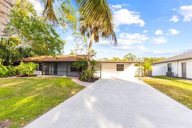 ranch-style house featuring cooling unit, a garage, and a front yard