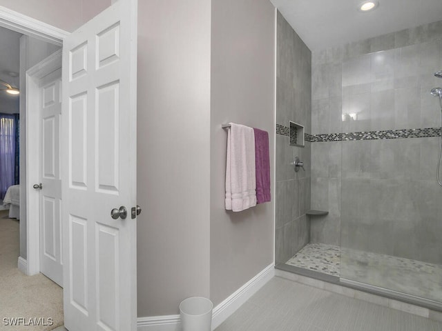 bathroom featuring tile patterned flooring and tiled shower