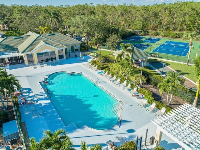 view of pool with tennis court and a patio