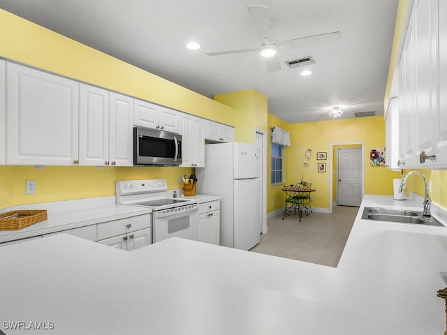 kitchen with sink, white appliances, ceiling fan, white cabinets, and kitchen peninsula