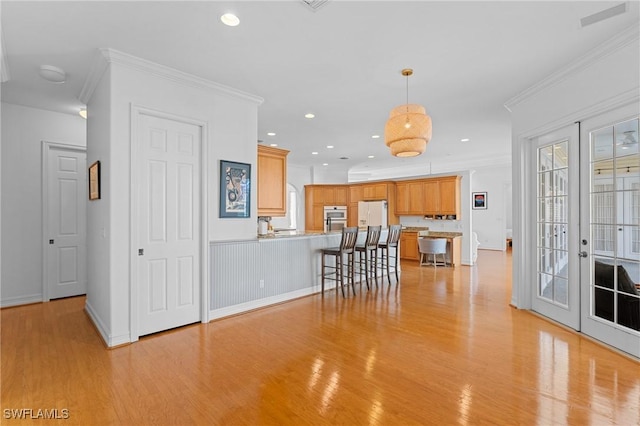 kitchen with decorative light fixtures, a peninsula, crown molding, french doors, and white fridge with ice dispenser