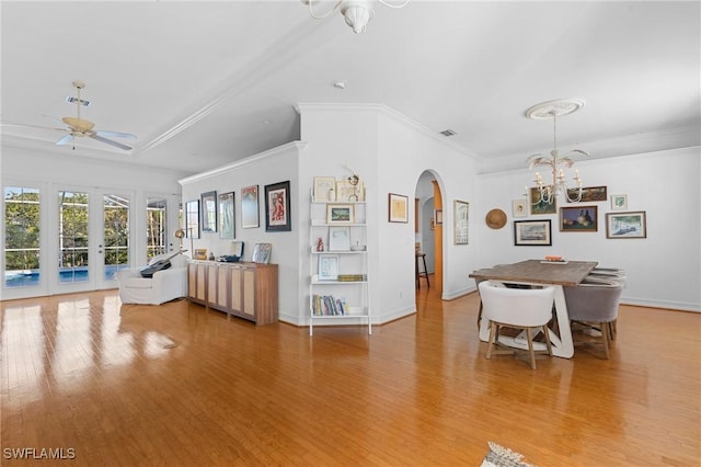 interior space featuring crown molding, ceiling fan with notable chandelier, light hardwood / wood-style floors, and french doors