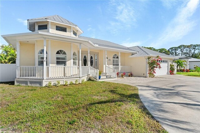 view of front of house featuring a garage, a front yard, and covered porch