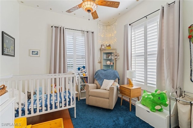 bedroom featuring dark colored carpet and a nursery area