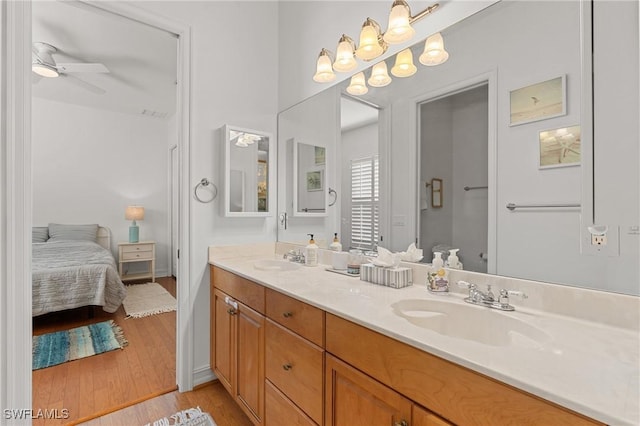 ensuite bathroom featuring ensuite bathroom, double vanity, wood finished floors, and a sink