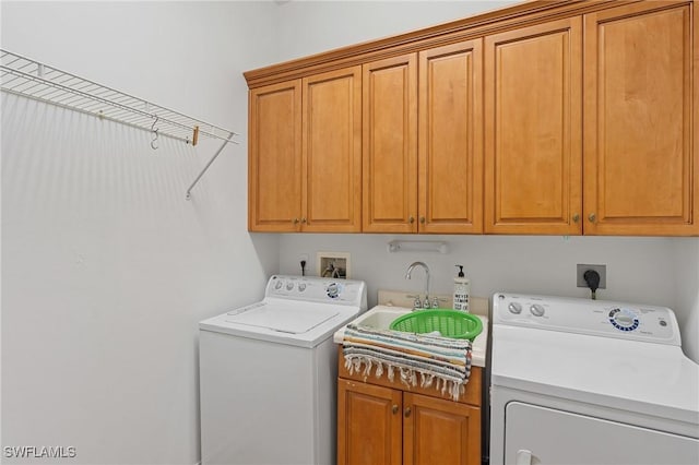 laundry area with cabinet space, washer and clothes dryer, and a sink