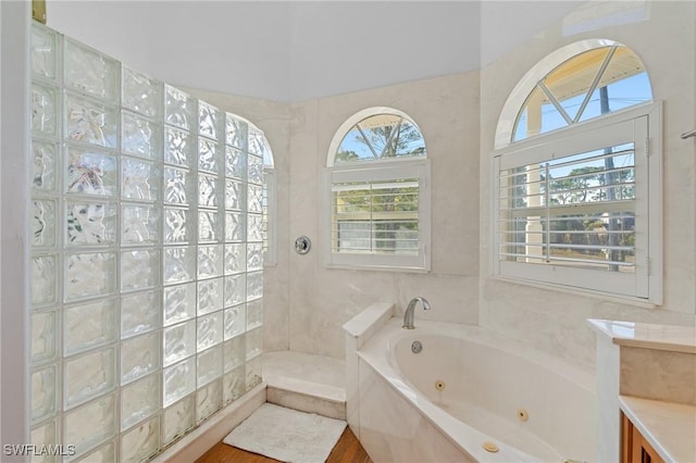 full bathroom featuring a walk in shower, a tub with jets, and a wealth of natural light