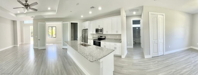 kitchen with sink, ceiling fan, stainless steel appliances, light stone countertops, and white cabinets