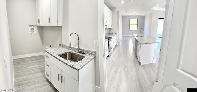 kitchen featuring white cabinetry, light stone countertops, sink, and appliances with stainless steel finishes