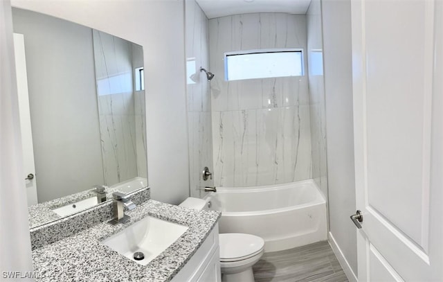 full bathroom featuring vanity, tiled shower / bath combo, and toilet