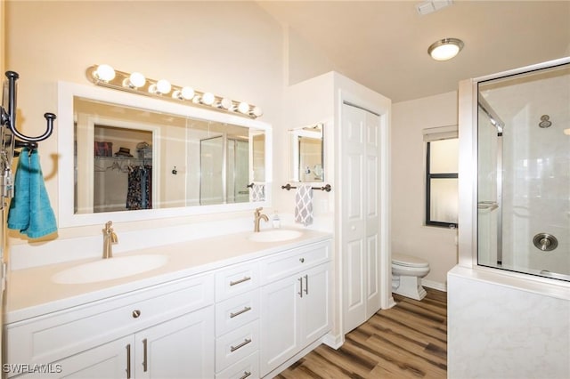 bathroom featuring an enclosed shower, vanity, hardwood / wood-style flooring, and toilet