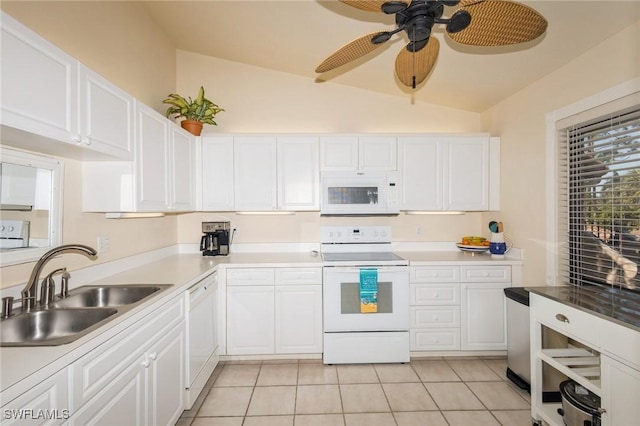 kitchen with vaulted ceiling, sink, white cabinets, light tile patterned floors, and white appliances