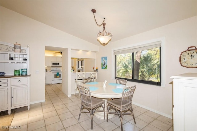 tiled dining space with vaulted ceiling