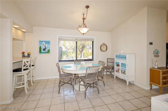 dining space featuring vaulted ceiling and light tile patterned flooring