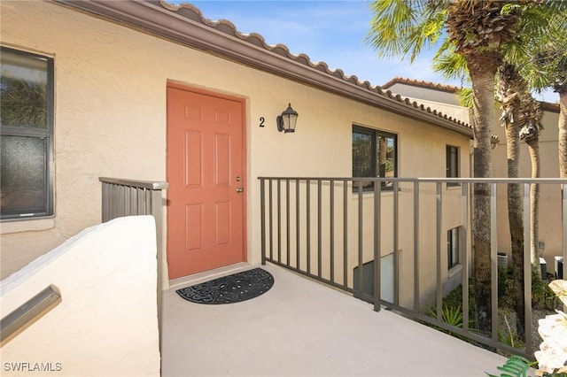 view of exterior entry featuring a balcony