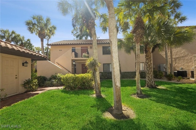 exterior space with a balcony, a yard, and central AC