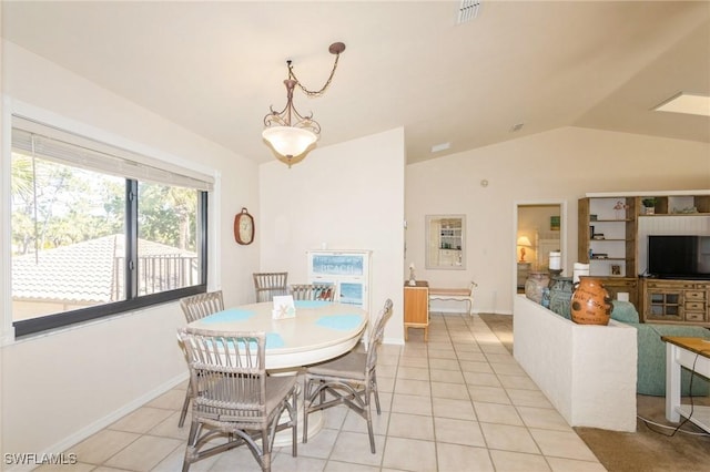 tiled dining space featuring lofted ceiling