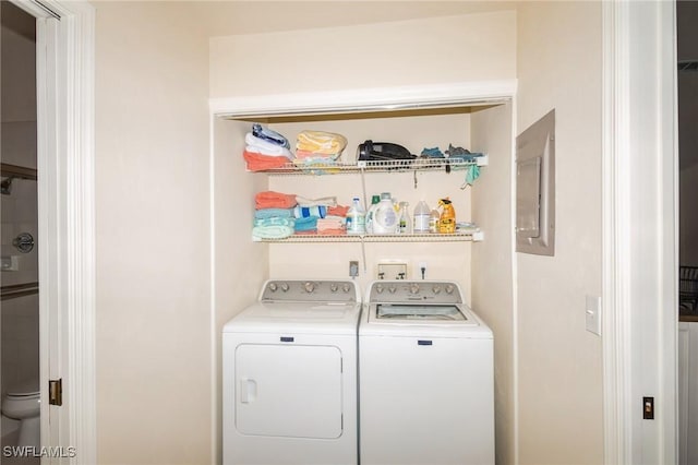 clothes washing area with separate washer and dryer and electric panel