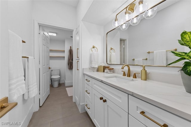 bathroom featuring vanity, toilet, and tile patterned flooring