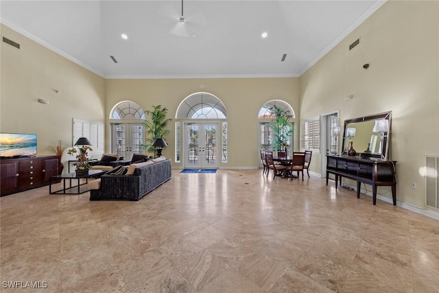 living room featuring a high ceiling, ornamental molding, and french doors