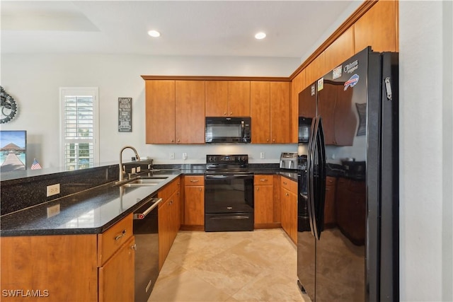 kitchen featuring dark stone countertops, sink, kitchen peninsula, and black appliances