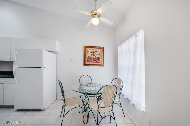 tiled dining room featuring lofted ceiling and ceiling fan