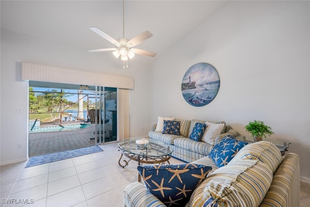 tiled living room with ceiling fan and high vaulted ceiling