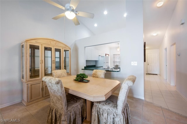 tiled dining room featuring ceiling fan and high vaulted ceiling